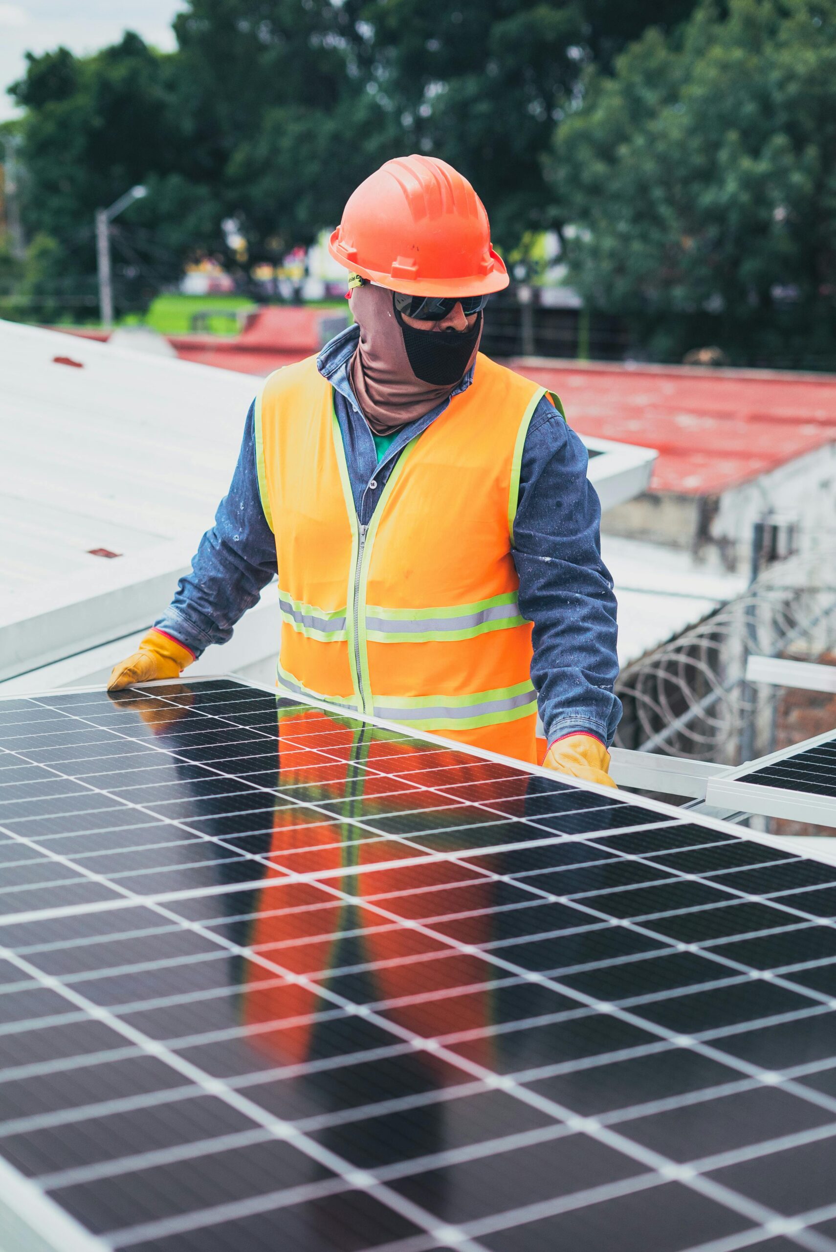 AmpliSolar Technician in protective gear installing solar panels on a sunny day.